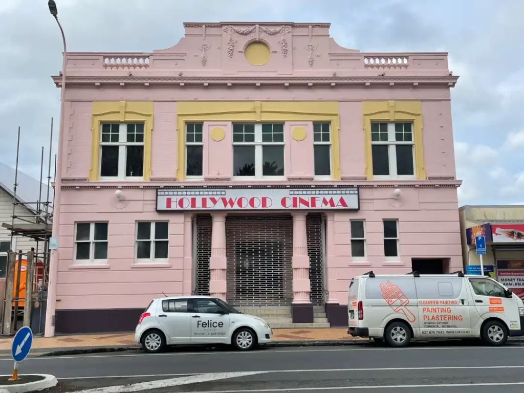 a pink building with white vans parked in front of it
